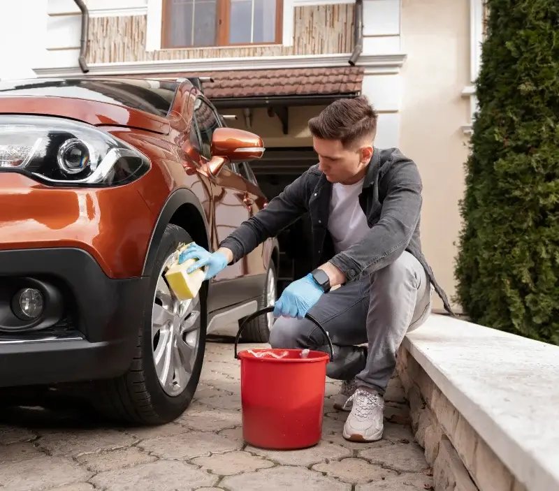Lavage auto à domicile Féneyrols : professionnel intervenant sur un véhicule